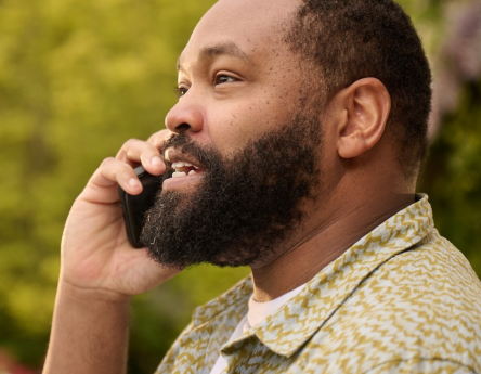Man with COVID on the phone outside contacting a healthcare professional