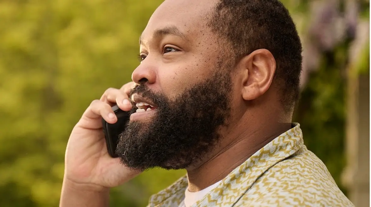 Man with COVID on the phone outside contacting a healthcare professional